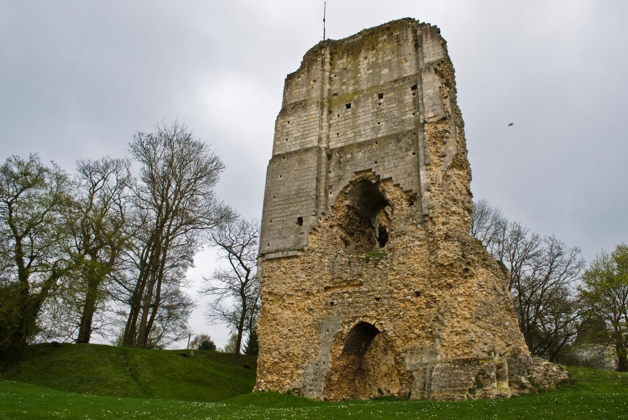 Le donjon de Brionne, tour carrée en ruine dressée sur sa colline d’herbe.