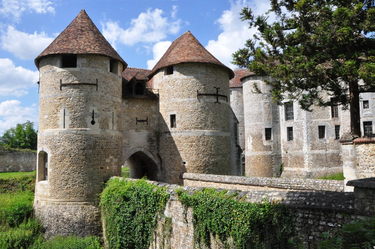 Le château d’Harcourt, ses deux grosses tours à toit conique et sa porte entre elles.